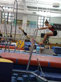 Gymnast performing a kip on uneven bars.